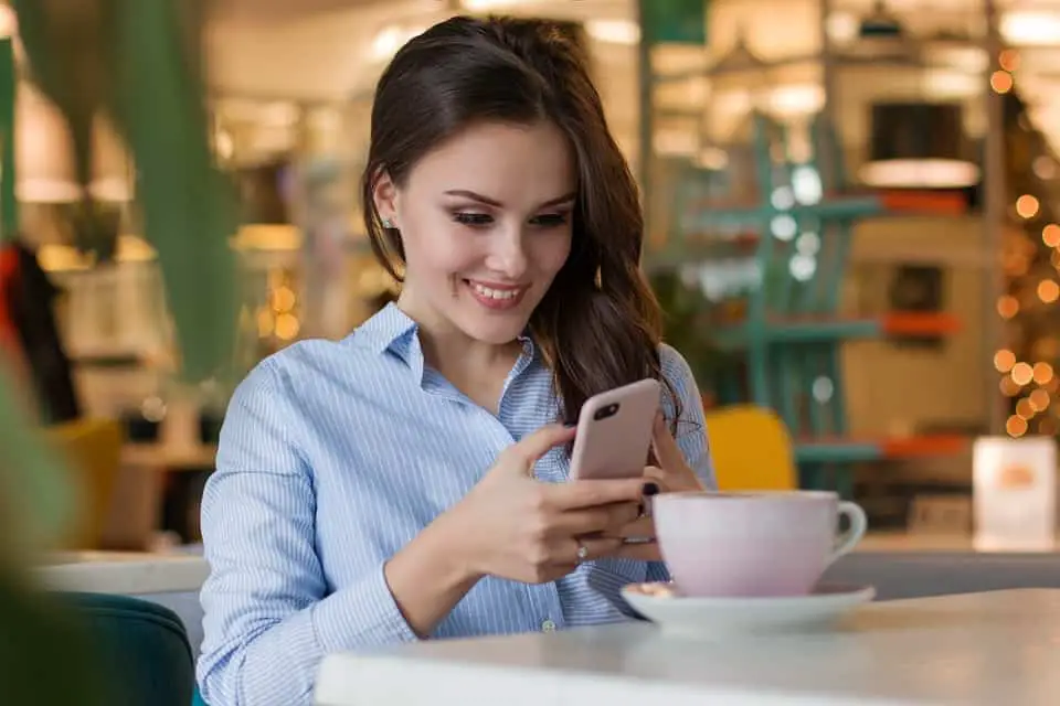 woman smiling while checking her phone