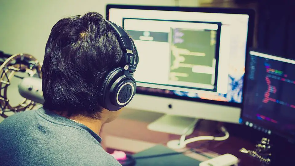 person wearing headphones doing some work on his computer