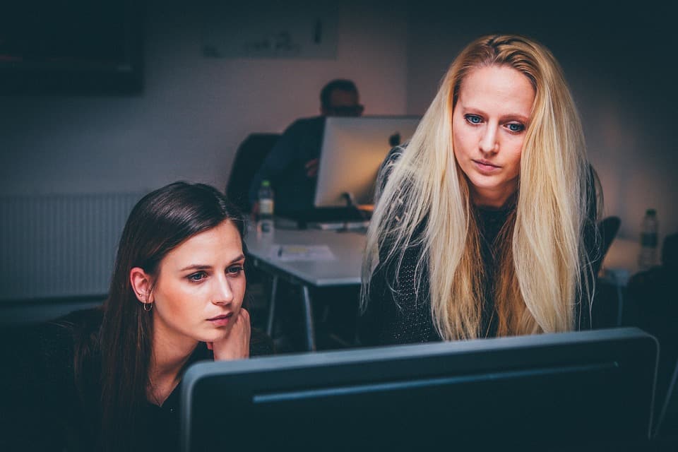 women checking out something in computer